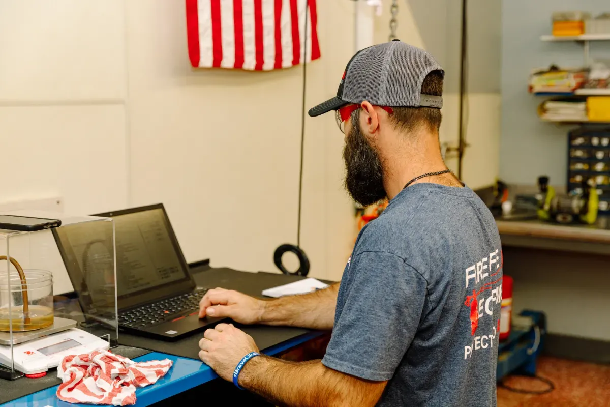 A man is sitting at a desk using a laptop computer.