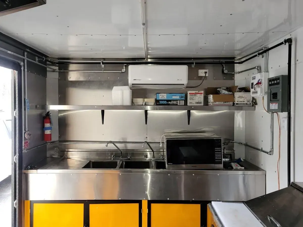 A kitchen with stainless steel appliances and yellow cabinets