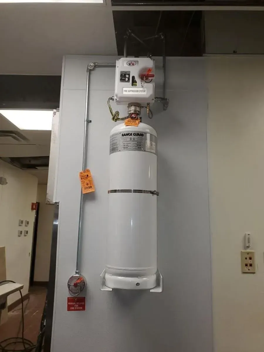 A white gas cylinder is hanging on a wall in a room.