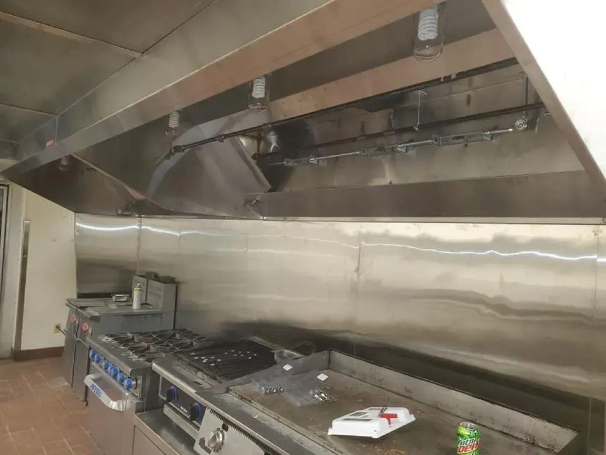 A kitchen with stainless steel appliances and a hood.