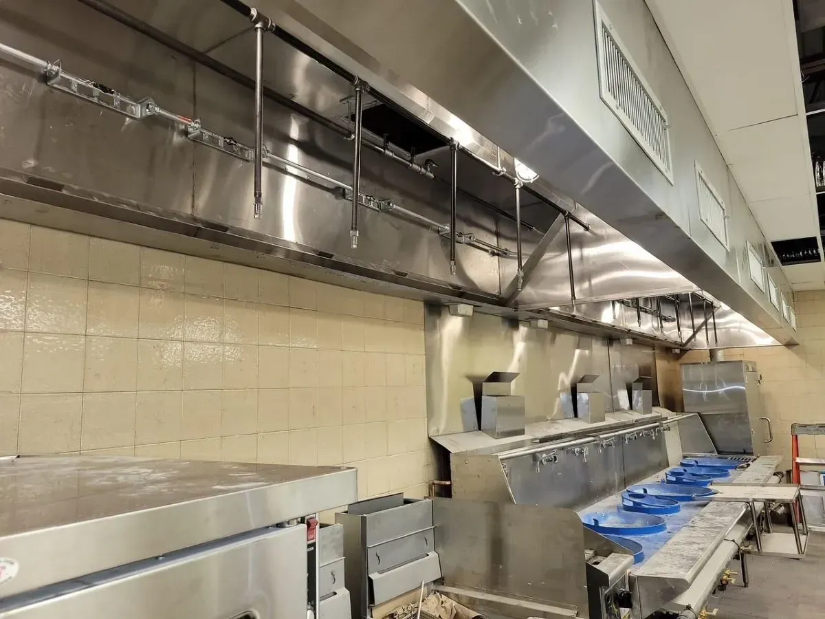 A kitchen with stainless steel appliances and a hood.