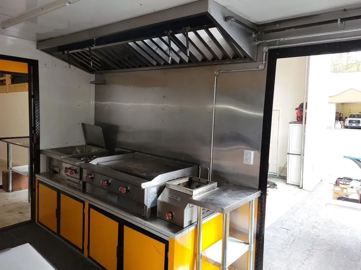 A kitchen with stainless steel appliances and yellow cabinets