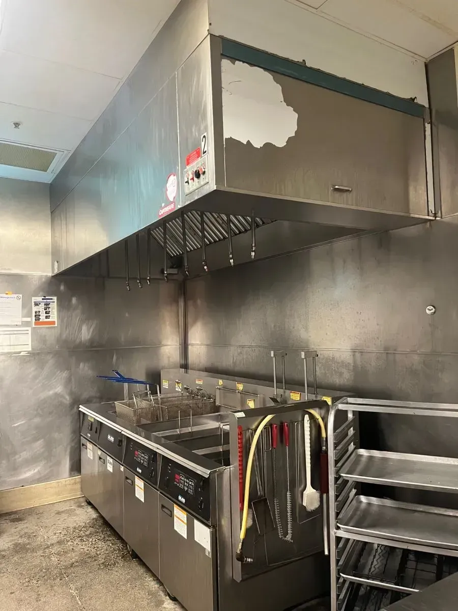 A kitchen with stainless steel appliances and a fryer.