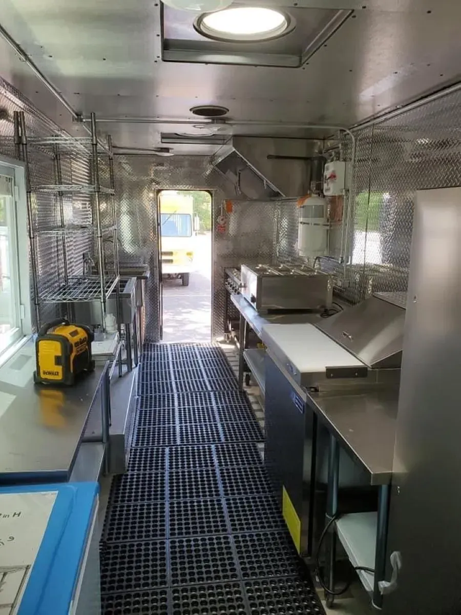The inside of a food truck with a lot of stainless steel appliances.