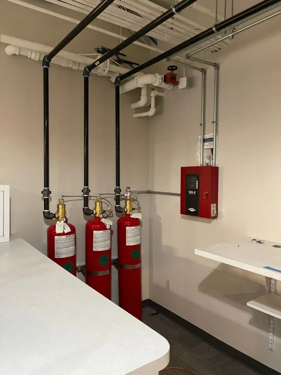 Three red fire extinguishers are lined up in a room