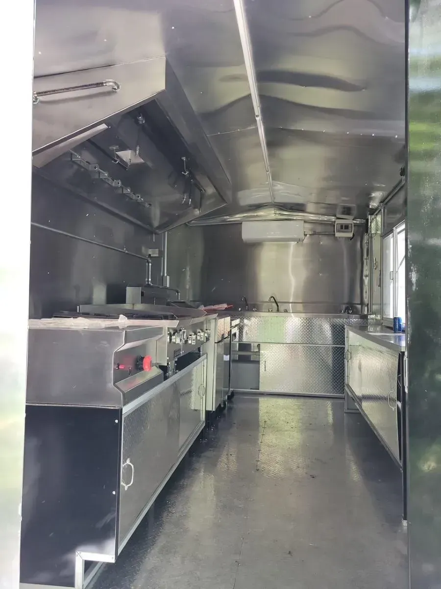 The inside of a food truck with a lot of stainless steel appliances.