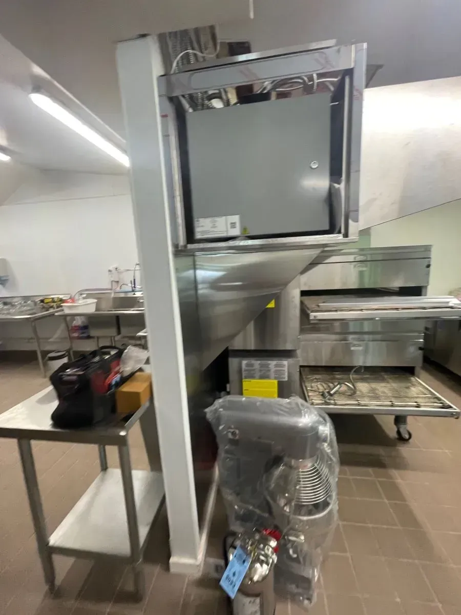 A kitchen with stainless steel appliances including a pizza oven