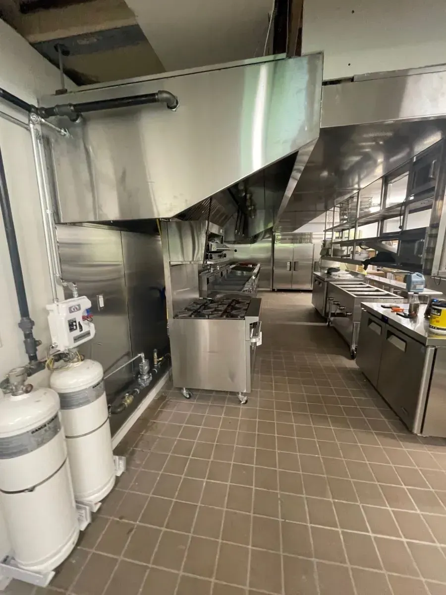 A kitchen with stainless steel appliances and a tiled floor.