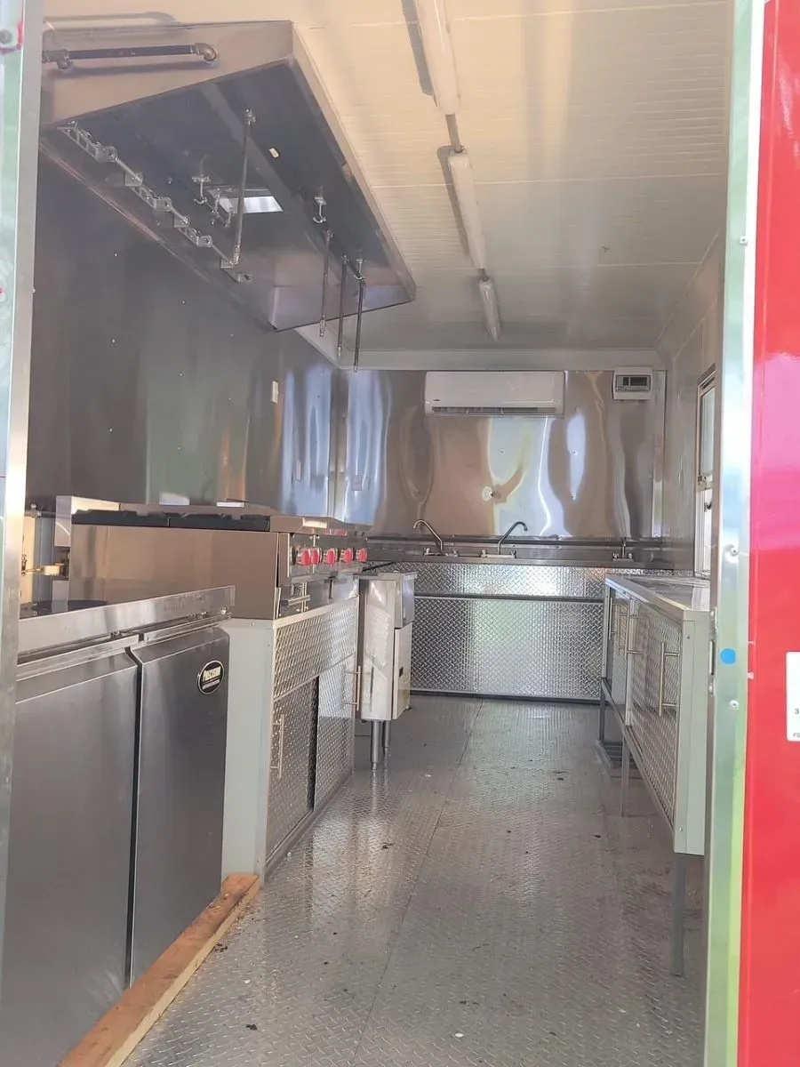 A kitchen with stainless steel appliances and a red door