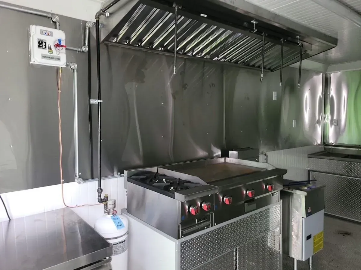 A kitchen with stainless steel appliances and a hood.