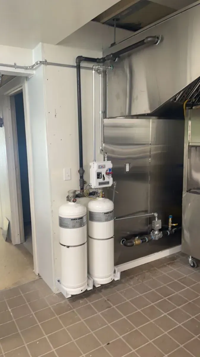 A kitchen with stainless steel appliances and two gas tanks.