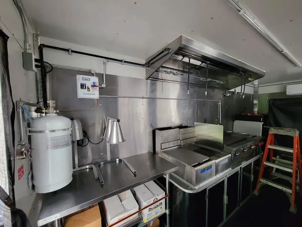 A kitchen with stainless steel appliances and a ladder.