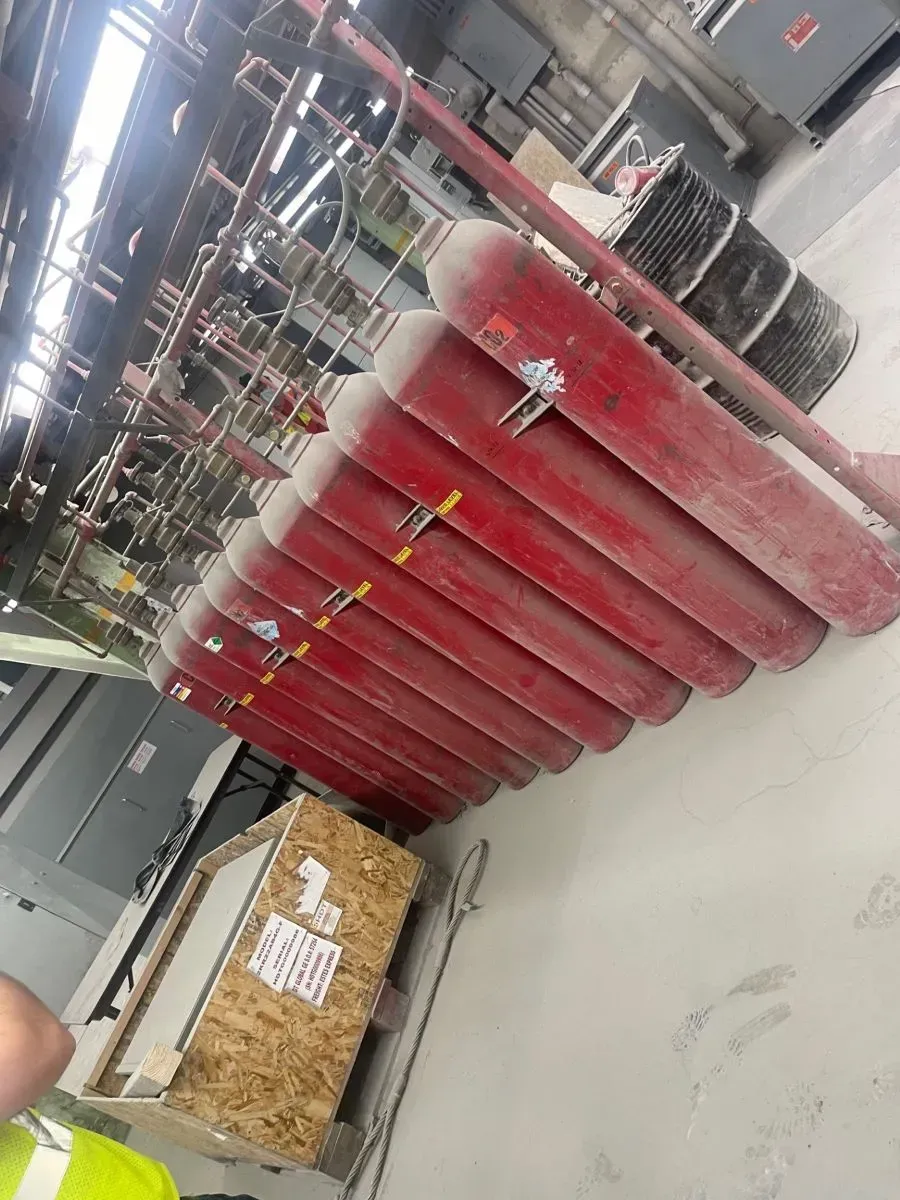 A bunch of red gas cylinders are stacked on top of each other