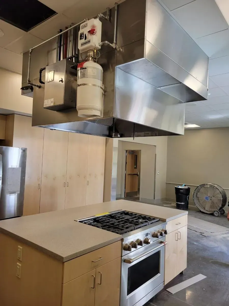A kitchen with stainless steel appliances and a stove top oven.