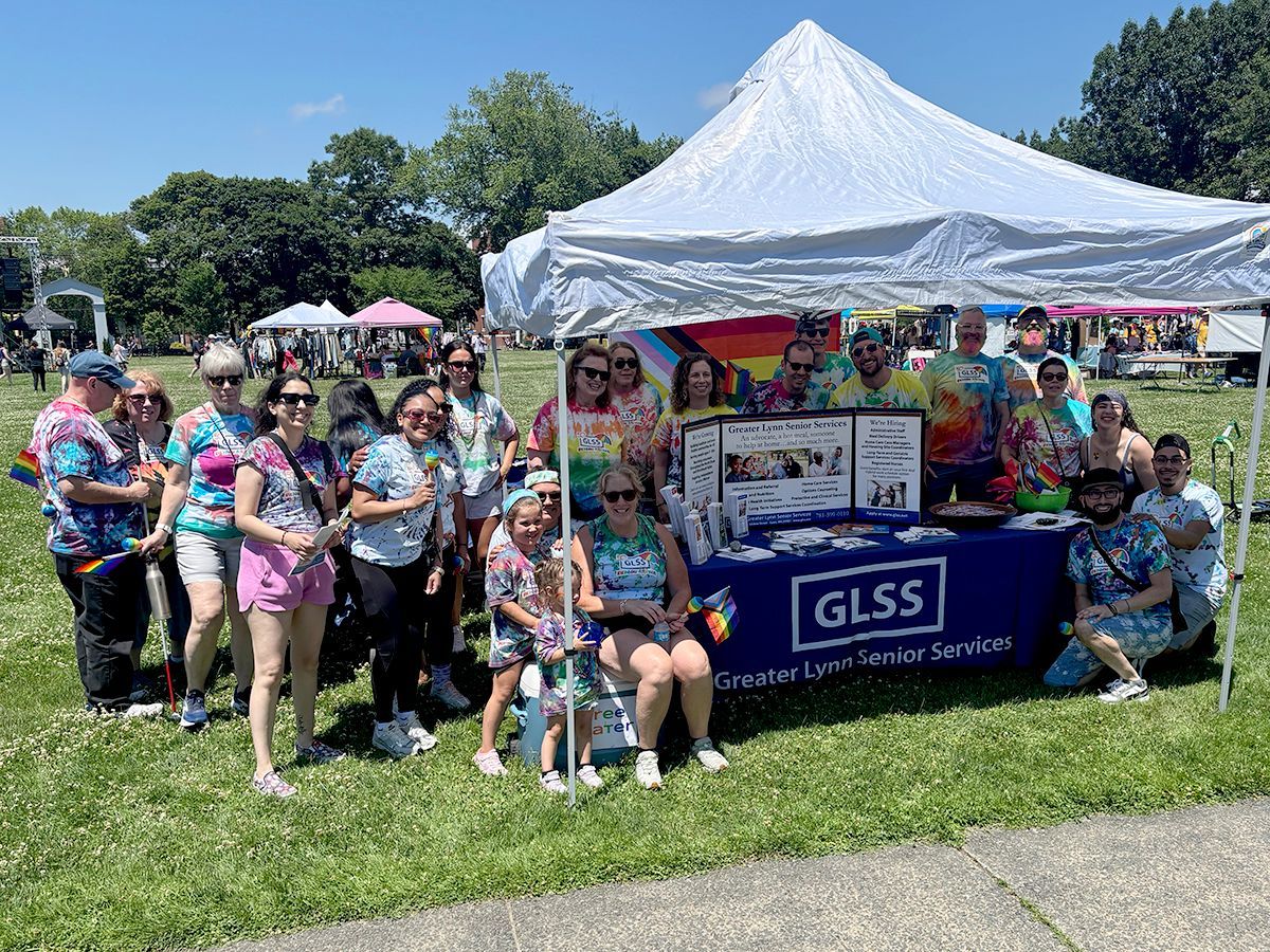 Group at a GLSS booth under a white tent at an outdoor community event