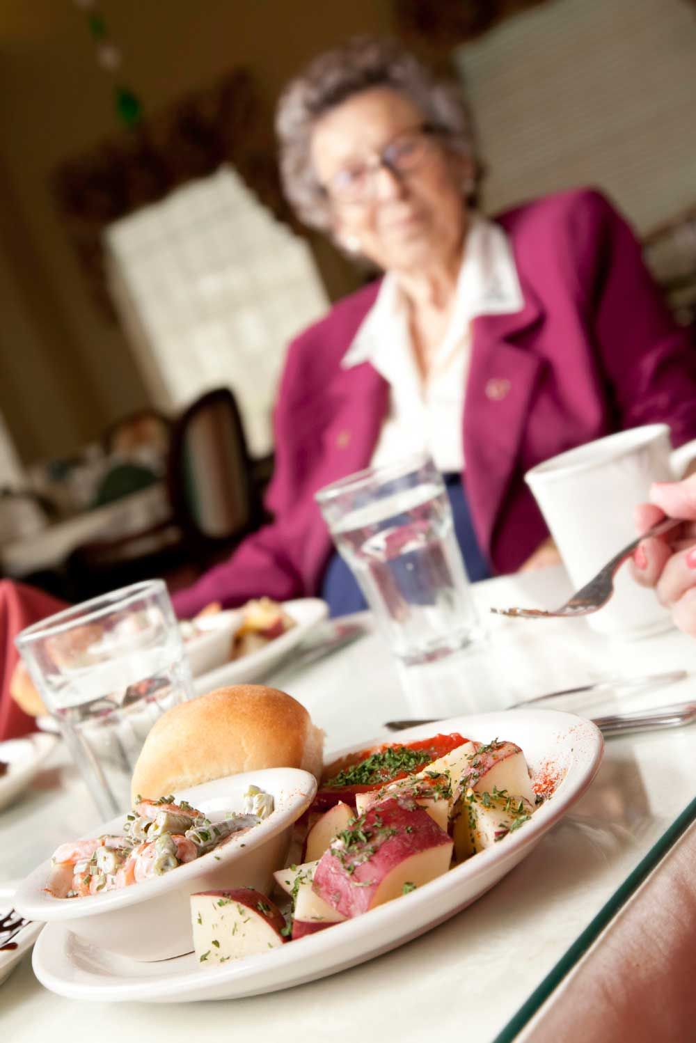 Woman eating lunch at a communal table.