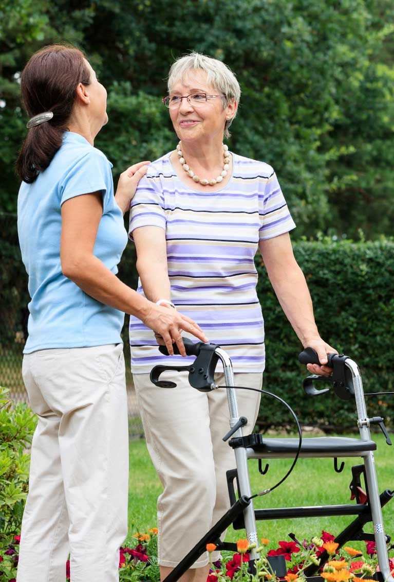 Woman with walker and friend outdoors