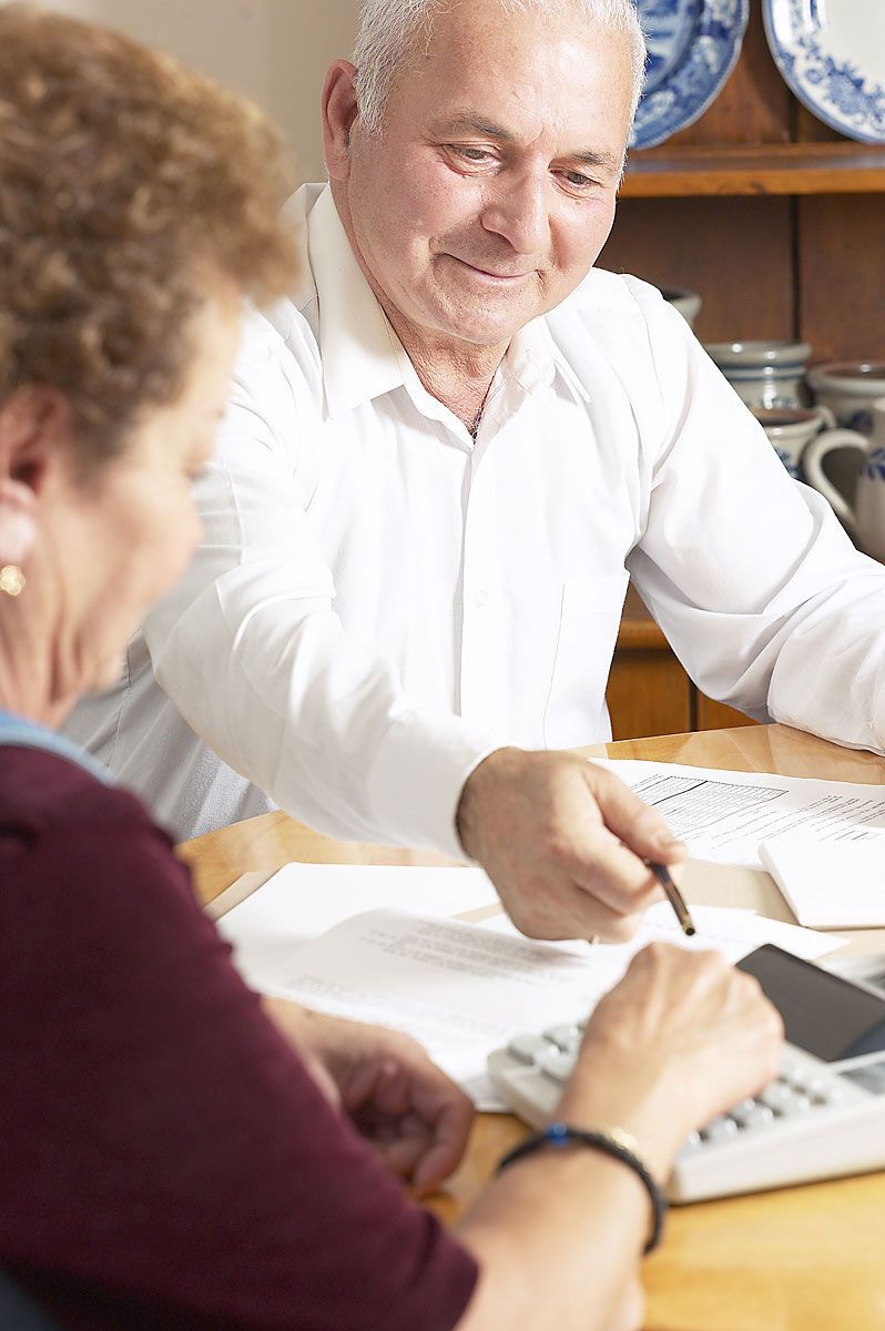 Man and woman looking at paper bills on a table