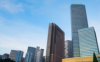City skyline with tall modern skyscrapers under a clear blue sky.