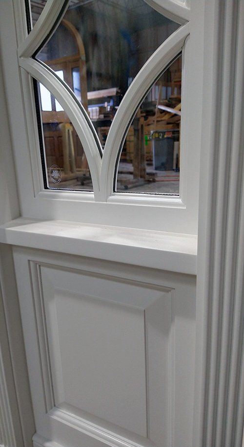 A close up of a white door with a window.