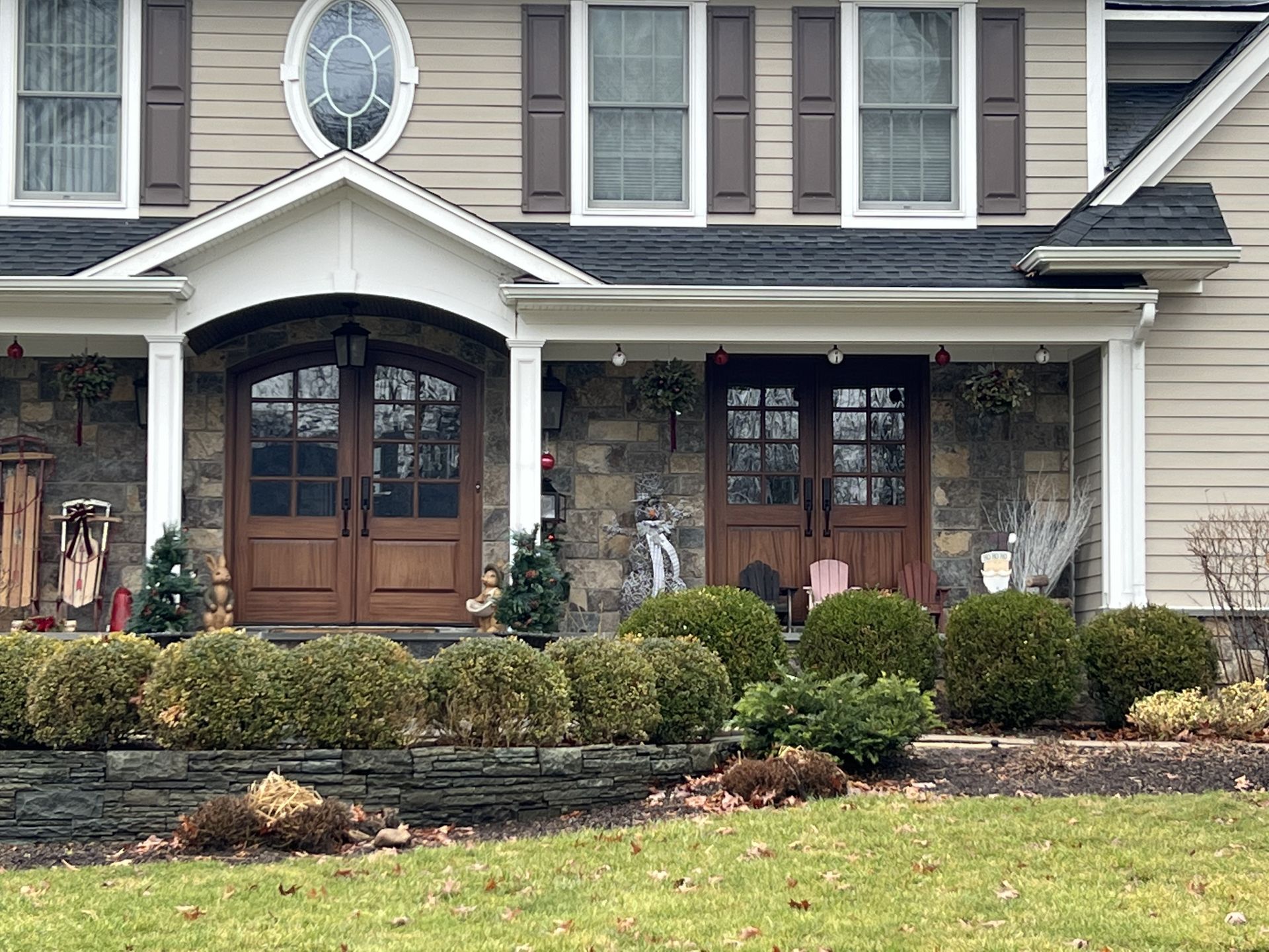 A large house with a porch and a stained glass window.