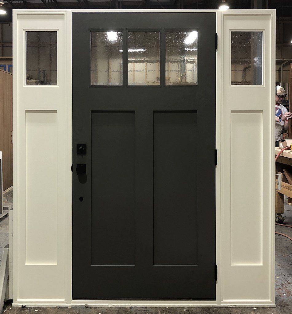 A black door with white trim is sitting in a room