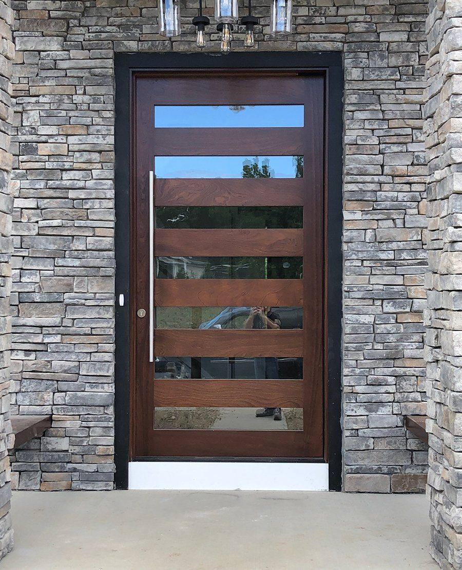 A wooden door with a stone wall behind it