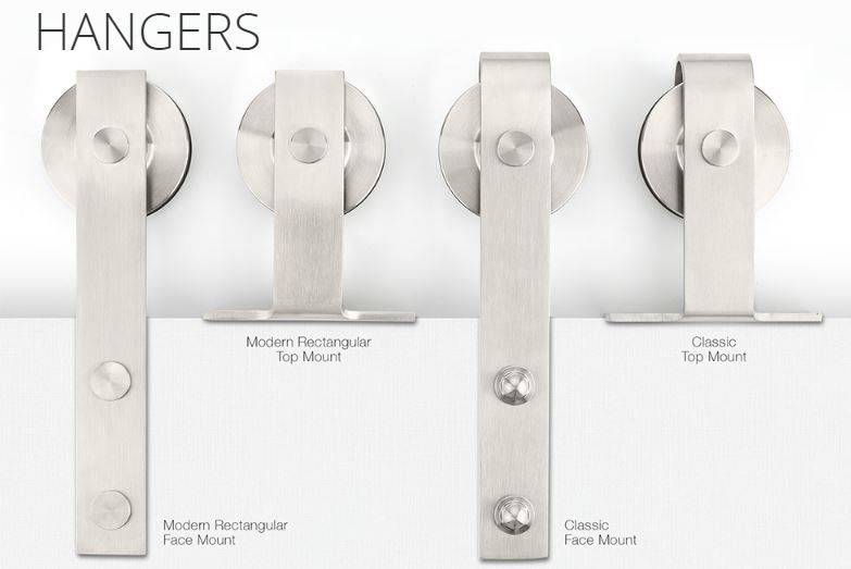 Four stainless steel hangers are lined up on a white surface.