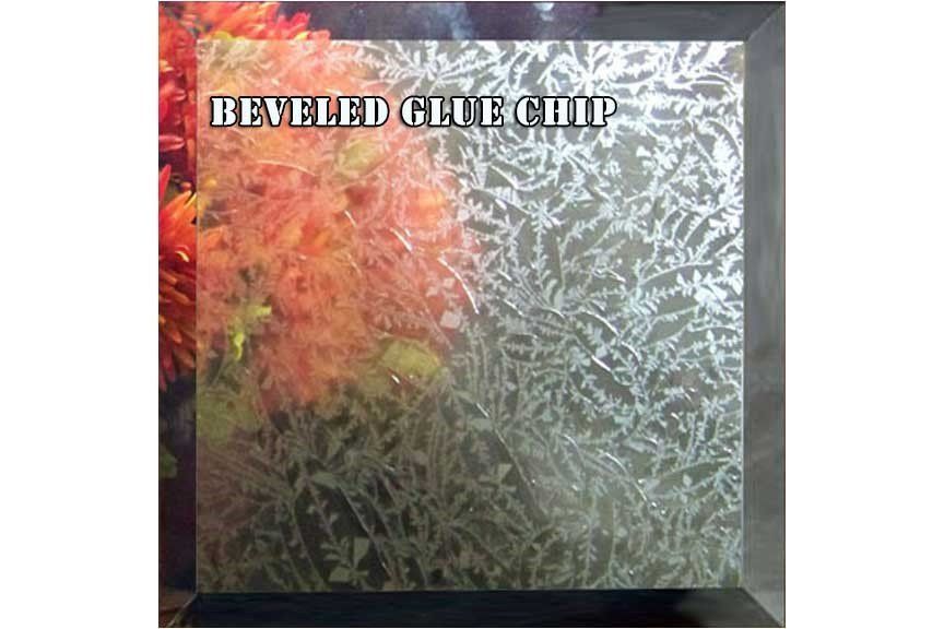 A picture of a beveled glass chip with flowers in the background.