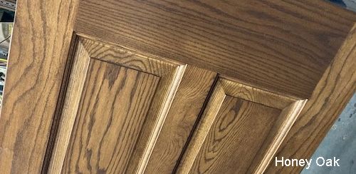 A close up of a wooden door in honey oak.