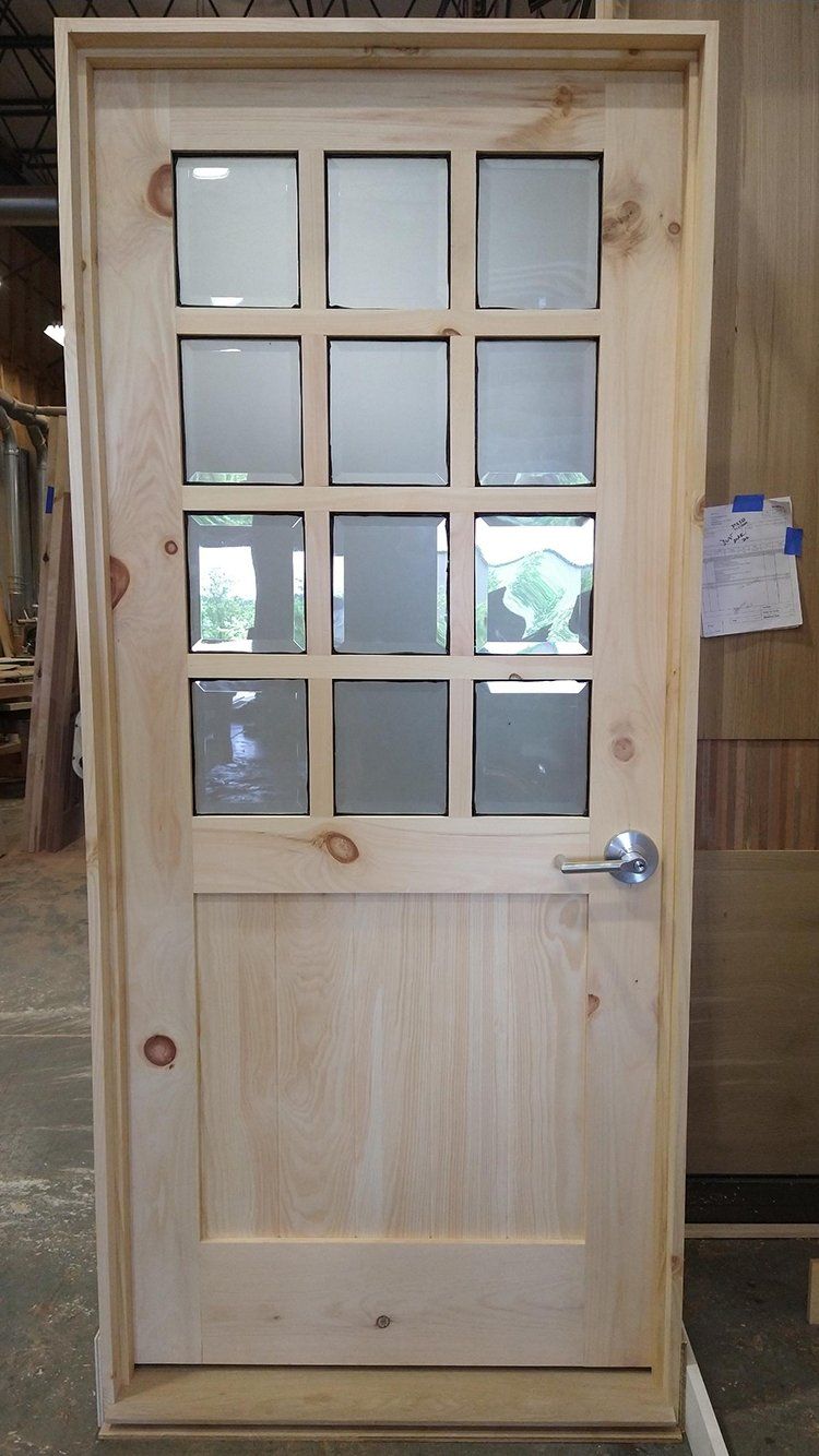 A wooden door with glass panels is sitting on a table.