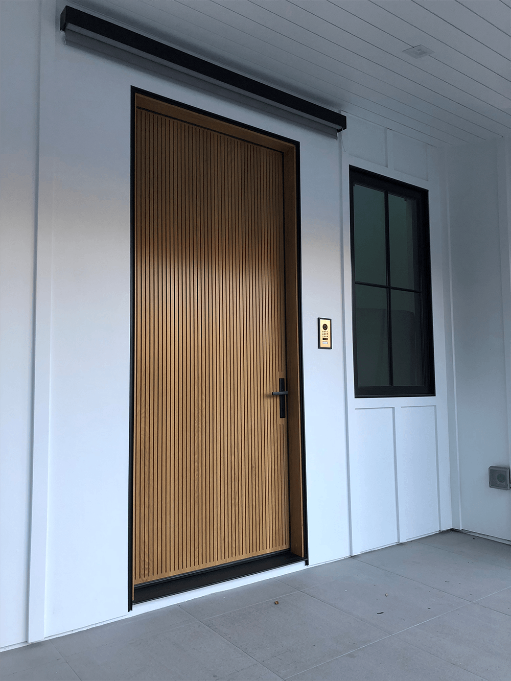 A white building with a wooden door and a window