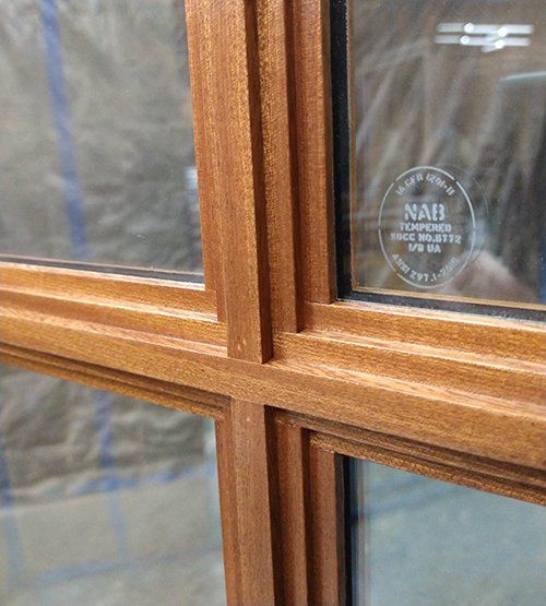 A close up of a wooden window with a nah sticker on it