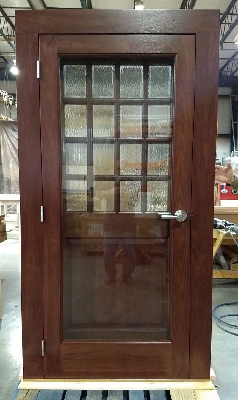 A wooden door with a glass window is sitting on top of a wooden pallet.
