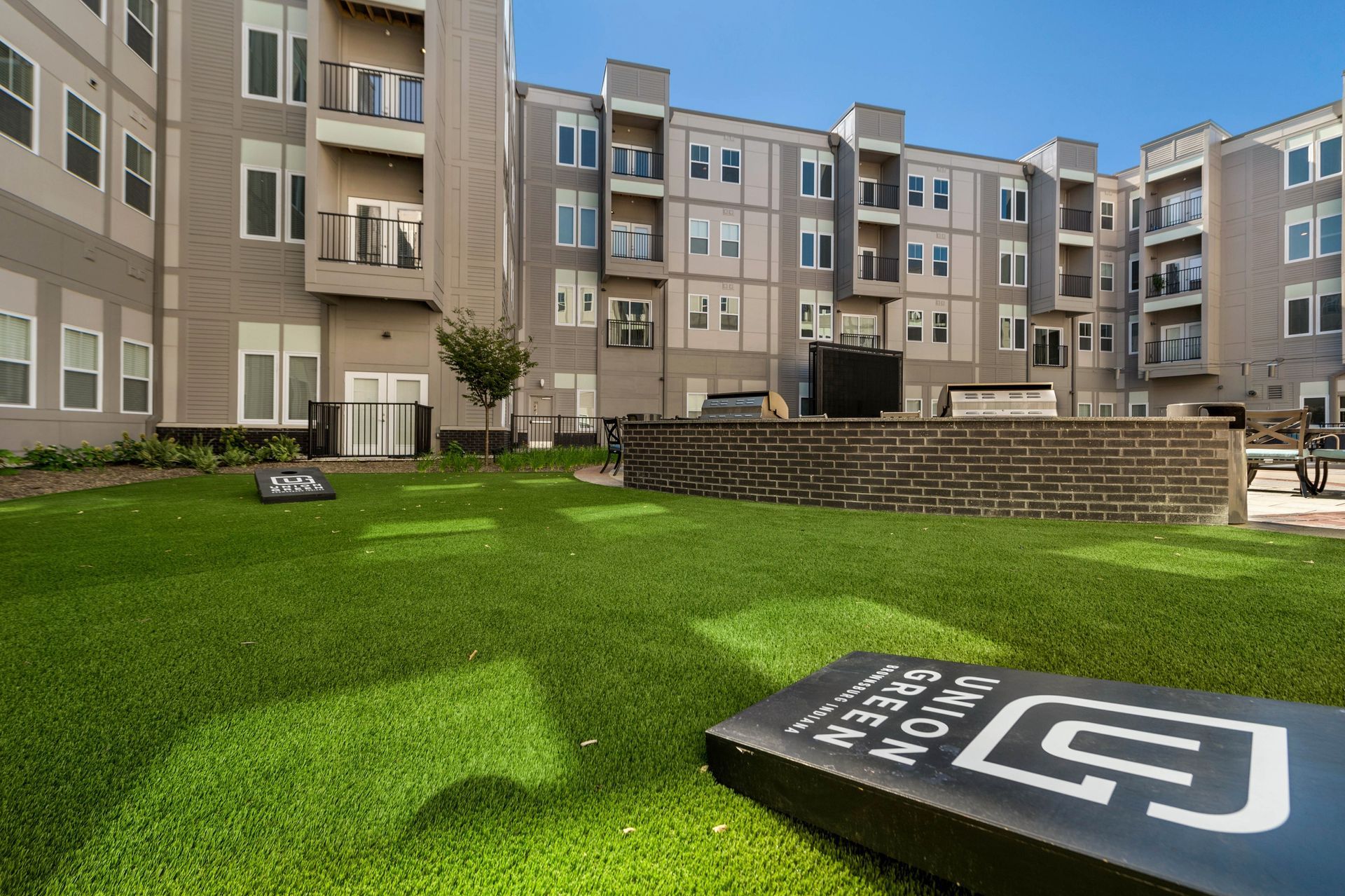 A large apartment building with a putting green in front of it.