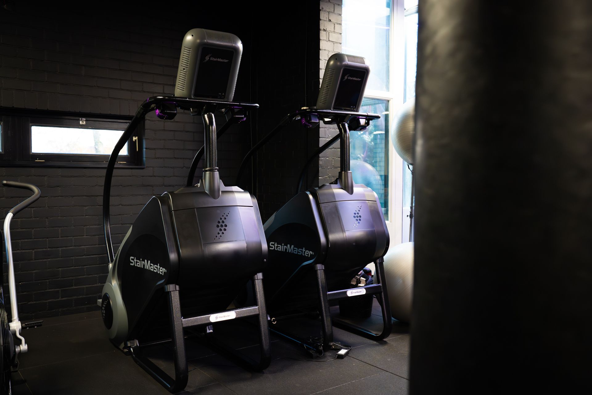 Twee zwarte hometrainers in een schemerig verlichte sportschool.