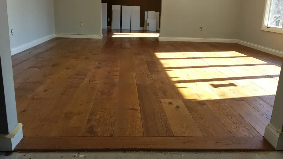 A living room with hardwood floors and a window.
