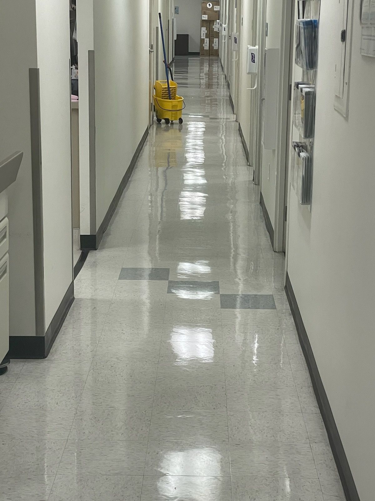 A long hallway with a yellow mop on the floor