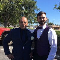 Two men in suits and bow ties are posing for a picture.