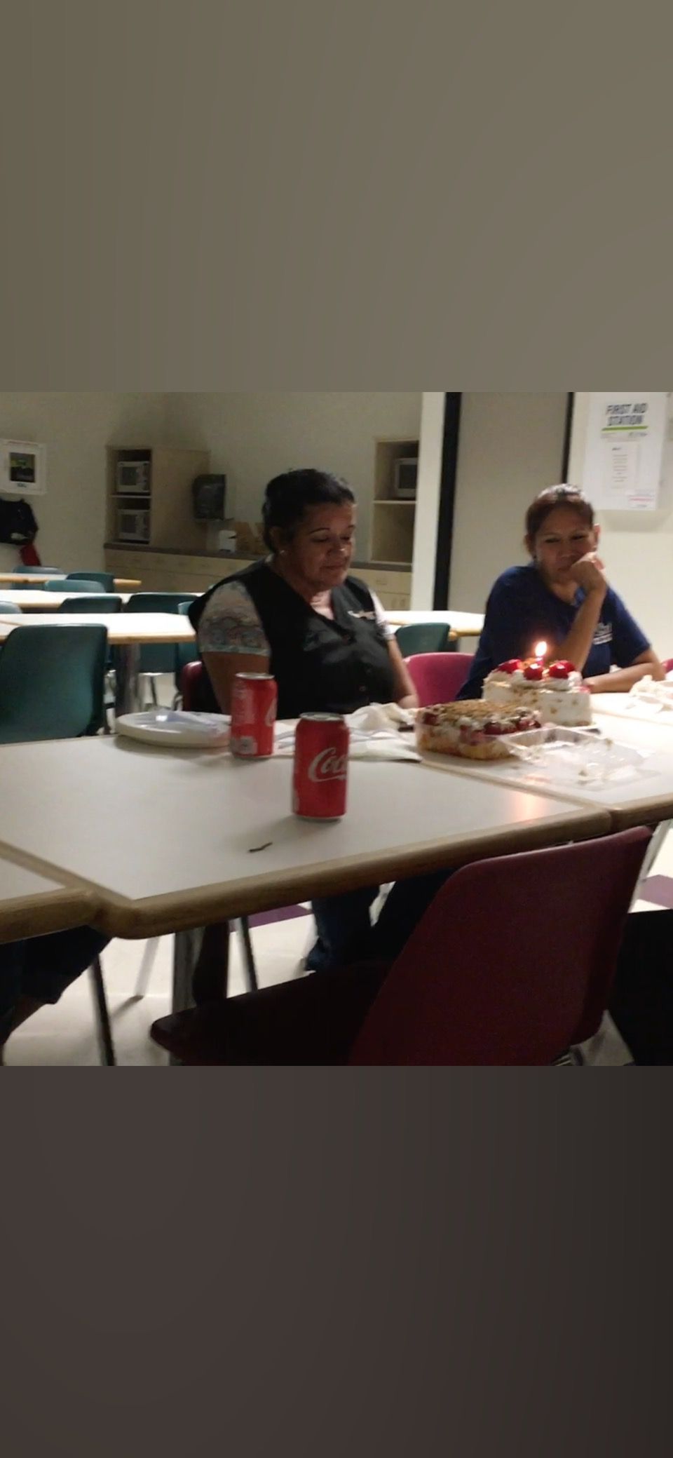 A group of people are sitting at a table with a can of soda on it.