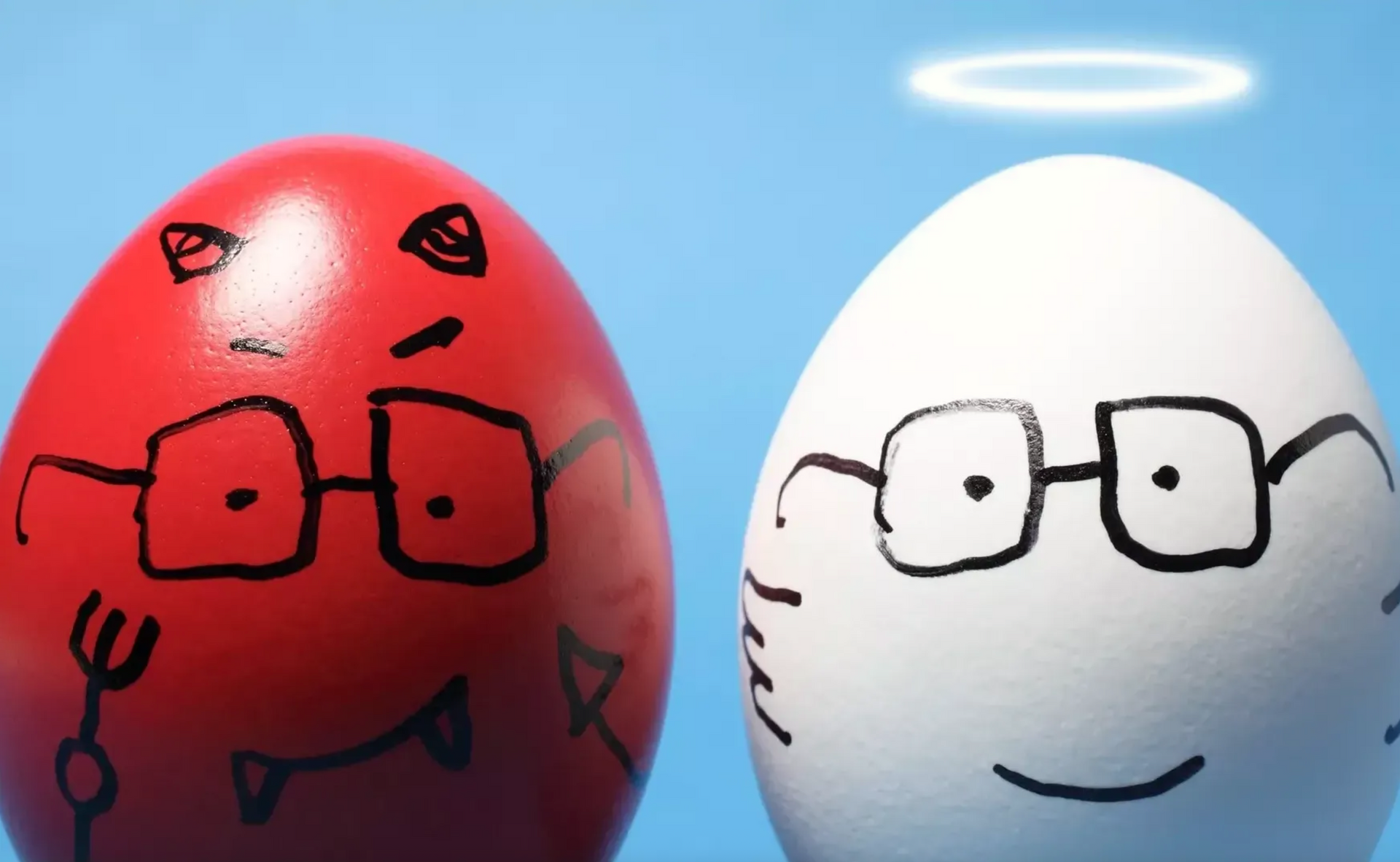 Red egg with devil horns and a white egg with a halo wearing glasses, representing good and evil.