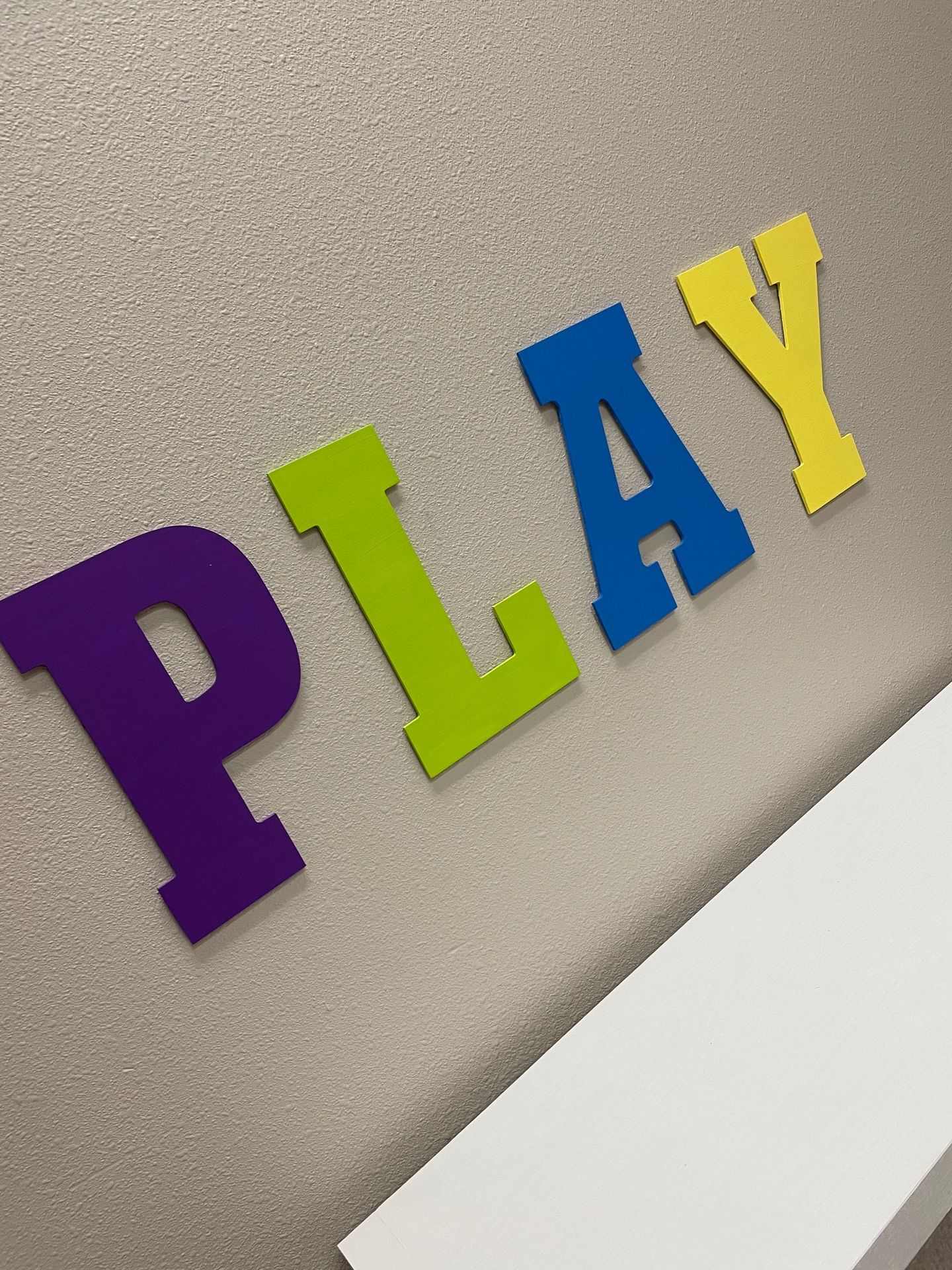 Decorative sign with the word “Play” at SpeakStrong Therapy