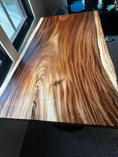 Assorted wooden boards and trim samples in light and dark finishes on a workshop surface
