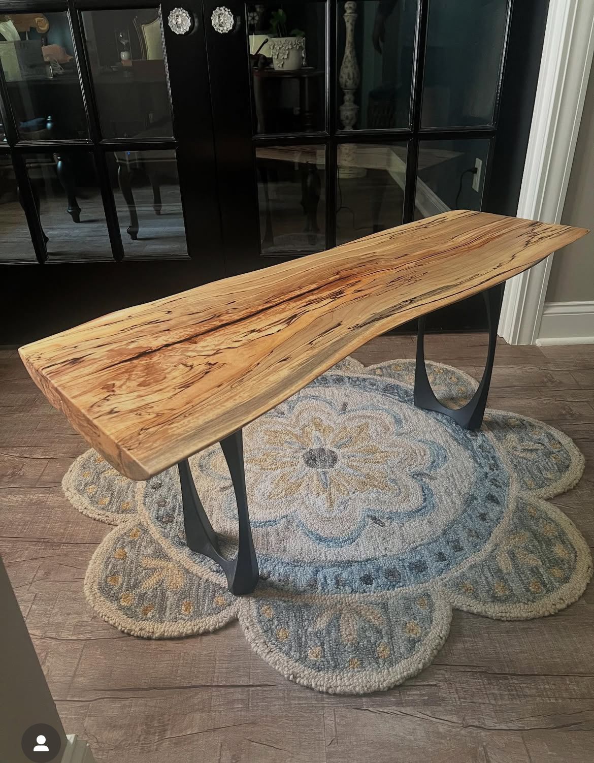 A wooden table is sitting on a balcony next to a railing.