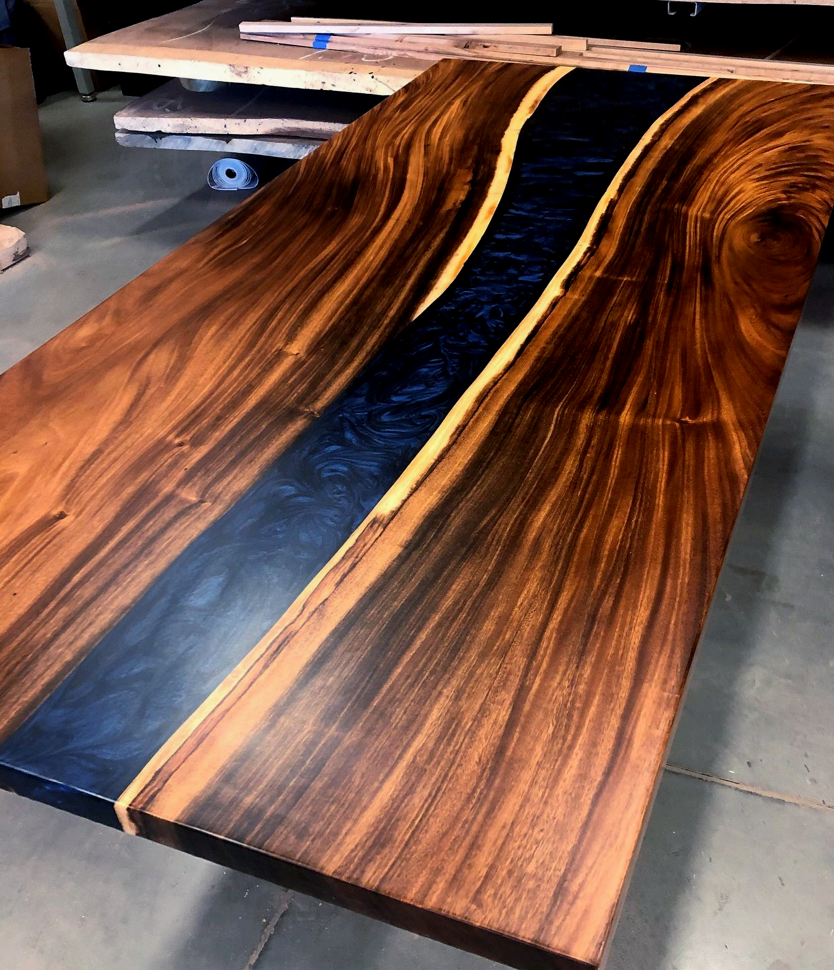 Wooden table with dark blue resin river.