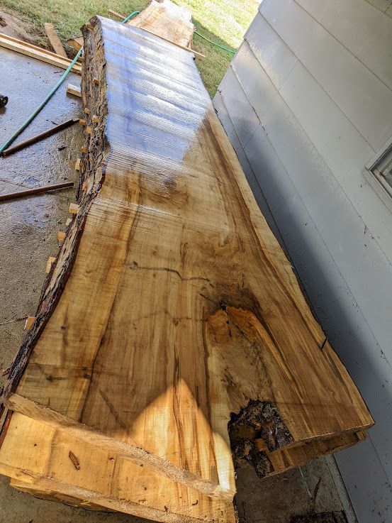 A close up of a stack of wooden boards on a wooden floor.