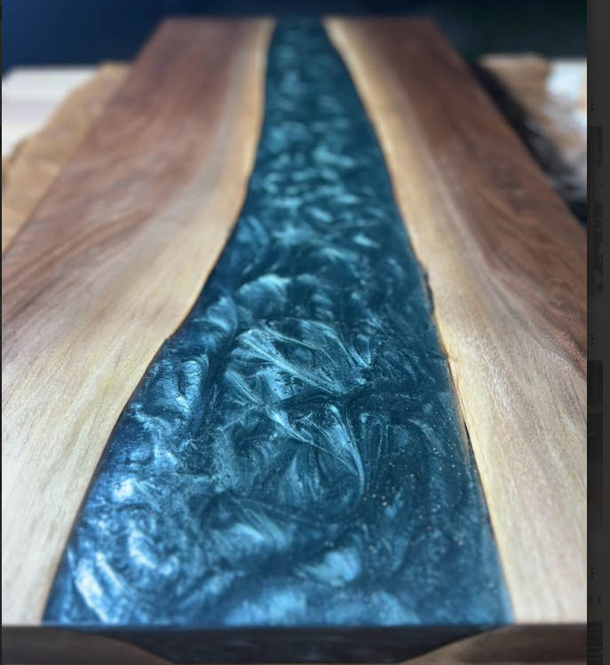 Wood slab tabletop with a glossy blue resin river in the center