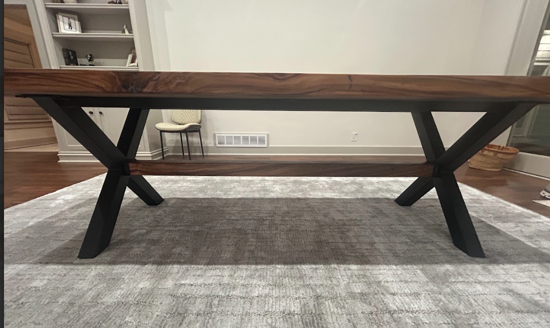 Wooden bench with black metal X-legs on a gray rug in a living room