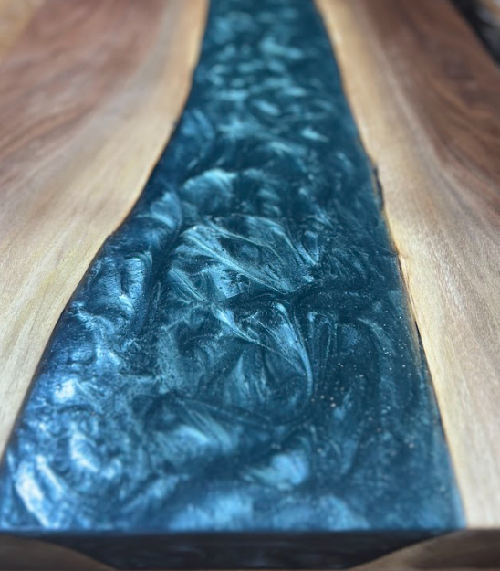 Wooden table with a dark blue, resin-filled river running down the center.
