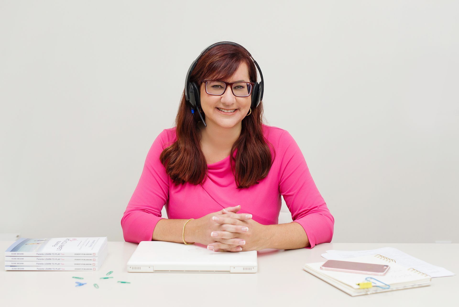 Susie Beghin seated at her desk wearing headphones.